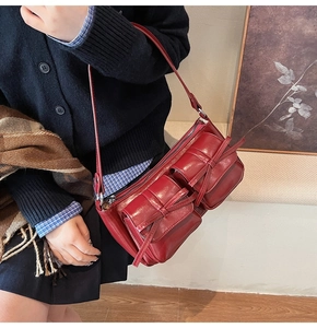 Detail of wine red PU leather shoulder bag featuring vintage bow accents and pockets