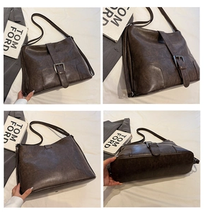 Detailed macro view showing the vintage leather texture and buckle of the brown bag