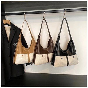 Winter faux fur and PU leather hobo bags in brown and black on metal display