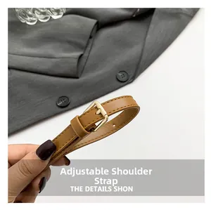 Detail of adjustable brown leather shoulder strap with gold buckle and fine stitching