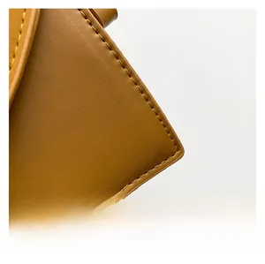 Detailed view of ginger leather bag showing precise stitching and premium micro-texture
