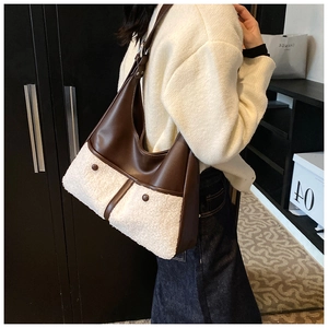 Detail of winter crossbody bag featuring brown faux leather and soft cream plush texture