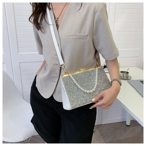 Close-up of sparkling silver rhinestone evening clutch with elegant pearl handle and gold lock