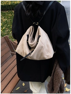 Macro detail of beige suede tote bag showing soft texture and gold ring metal buckle