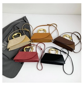 Detail of five assorted leather handbags featuring artistic golden metal handles in a fan layout