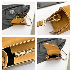 Detail view of mustard yellow square bag showing metal handle and interior zipper