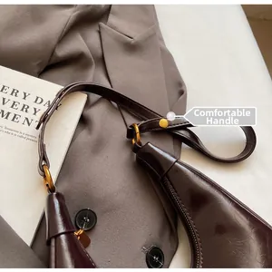 Detail of comfortable handle and shiny faux leather on vintage brown crescent bag