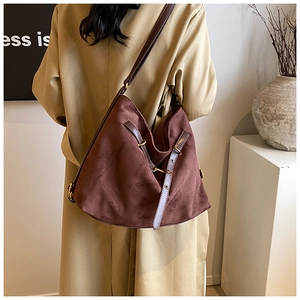 Detail of dark brown matte leather hobo bag showing gold hardware and strap stitching