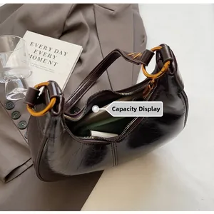 Macro view of dark brown oil wax leather hobo bag showing spacious interior capacity