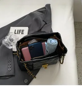 Interior view showing spacious capacity of black quilted chain bag for phone and umbrella