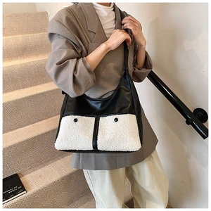 Detail of hobo bag featuring black leather contrast stitching and white lamb wool texture