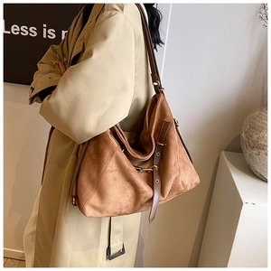 Detail of vintage matte brown tote bag with leather straps and retro hardware