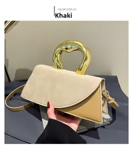 Detail of khaki suede crossbody bag with oversized gold semicircular metal handle