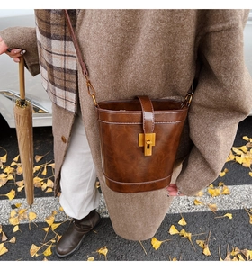 Détail d'un sac seau vintage en cuir ciré marron avec un fermoir tournant en métal robuste