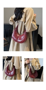 Detail view of deep red oil-wax leather hobo bag with sleek crescent silhouette