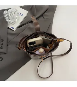 Vue de dessus d'un sac seau en cuir marron foncé montrant une grande capacité intérieure