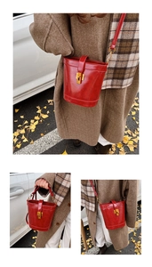 Détail du sac seau rouge en cuir ciré avec fermoir doré et bandoulière réglable