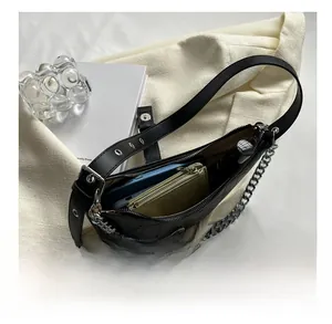 Detail shot of black crocodile pattern shoulder bag showing interior capacity and silver chain