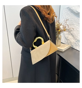 Detail of geometric shoulder bag featuring two-tone contrast and liquid gold metal handle