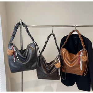 Trio of retro slouchy tote bags in black and brown with decorative bear charms