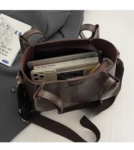 Spacious interior of dark brown croc-textured tote bag with daily essentials inside