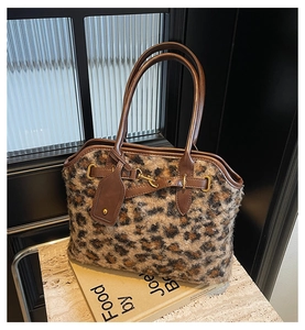 Détail du cabas en fausse fourrure léopard avec poignées en cuir et boucles dorées