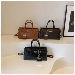 Detailansicht glänzender Ledertaschen mit Metallschnallen und Kettenverschluss-Akzenten
