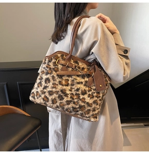 Détail d'un sac cabas en fausse fourrure léopard avec garniture en cuir brun et métal doré