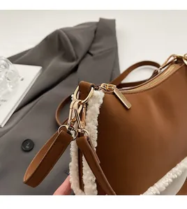 Close-up of premium gold hardware and plush shearling trim on a brown handbag