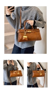Detailaufnahme der braunen Vintage-Handtasche mit goldener Schließe und Leder-Mikroanhänger