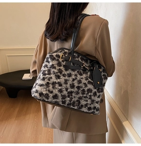 Détail du sac en peluche léopard avec poignées en cuir noir et finitions métalliques dorées