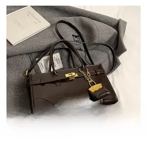 Detail einer dunkelbraunen Shopper-Tasche aus Ölwachs-Leder mit goldfarbenem Verschluss