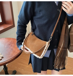 Brown suede crossbody bag with plush white faux shearling trim and golden metal zippers