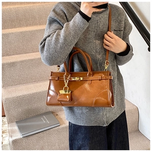 Braune Vintage Kunstledertasche mit Handgriffen und dekorativem Mini-Anhänger