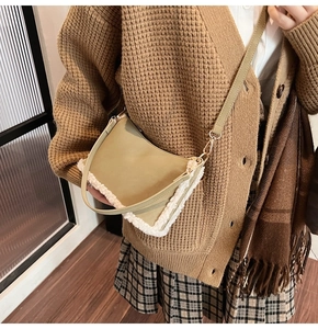 Detail of green faux leather shoulder bag with white fleece trim and gold hardware