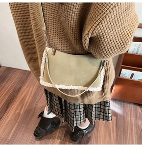Sac à main chic en cuir vert sauge avec bordure en peluche porté par un mannequin