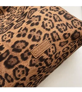 Detail of leopard print tote bag featuring a stitched brown leather CLEAR♥K logo patch