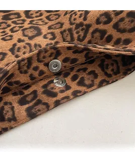 Detail of high-gloss silver magnetic buckles on a leopard print tote bag fabric