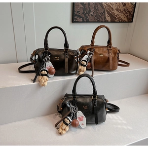 Boston bags in coffee, brown, and black with mini bear charms and gold logo detail