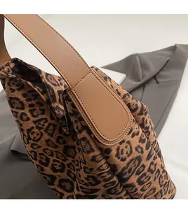 Detail of leopard print tote bag with brown leather straps and precise edge stitching