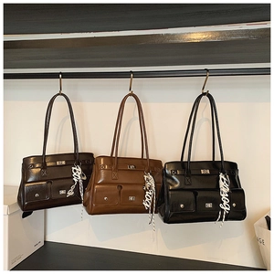 Detailed close-up of retro leather messenger bags in dark coffee, caramel, and black