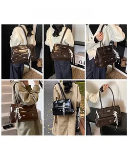 Detail view of large vintage shoulder bag with multiple pockets and white charm