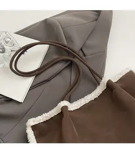 Detail of vintage brown suede tote with white faux fur trim on a grey suit background