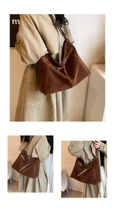 Detail shot of large brown suede tote bag with leather straps and golden metal buckles
