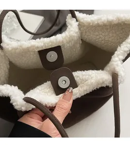 Detailed macro view of fleece lining and magnetic snap closure on brown tote bag