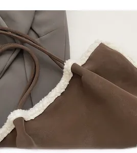 Detail of vintage suede bucket bag with plush white faux fur trim and fine stitching