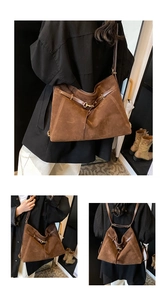 Detailed view of brown suede tote showing adjustable straps and gold buckle accents