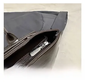 Macro shot of silver metal zipper detail on dark brown leather business briefcase