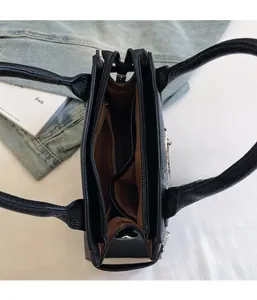 Top view of a black pebble leather handbag showing multi-compartment interior and zippers