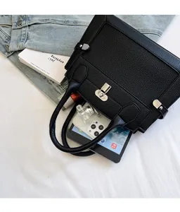 Internal view of black pebbled leather handbag showing capacity for tablet and phone